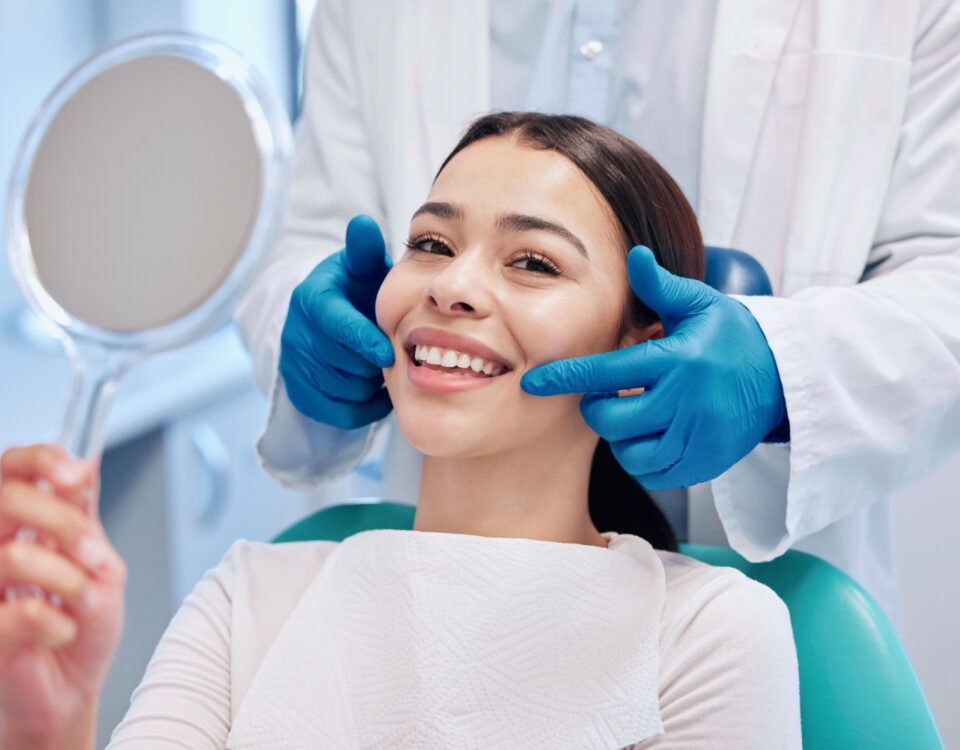 A person smiling as a dentist points their mouth