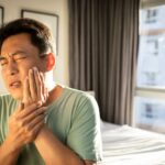 A person holding their jaw in pain