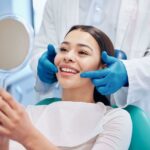 A person smiling while looking in the mirror at the dentist